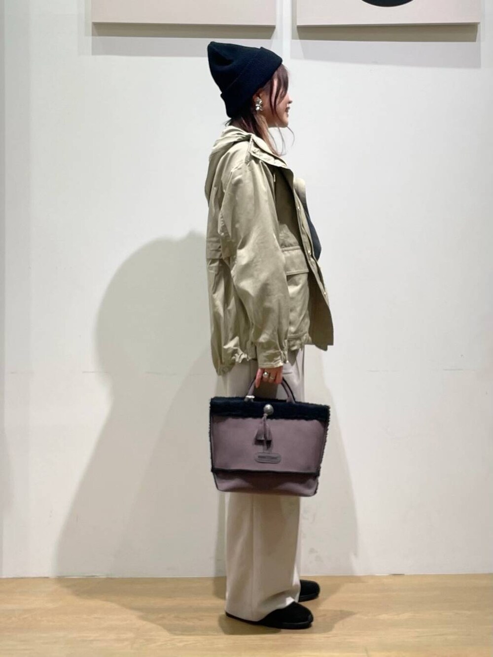 ブラウン系のマウンテンパーカー、グレー系のTシャツ/カットソー、ブラック系のブーツを着用したレディースの秋コーディネートの2枚目の写真