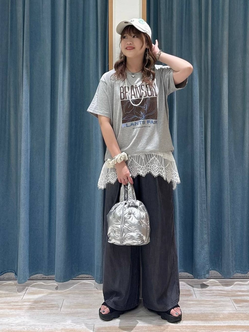 ブラック系のデニムパンツ、シルバー系のショルダーバッグ、ホワイト系のTシャツ/カットソーを着用したレディースの春コーディネートの4枚目の写真