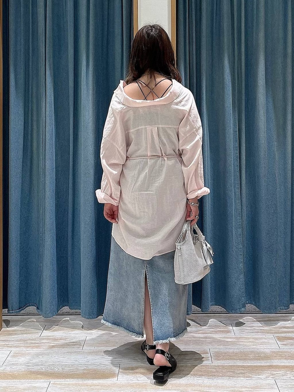 ブラック系のパンプス、ブルー系のデニムスカート、グレー系のショルダーバッグを着用したレディースの春コーディネートの3枚目の写真