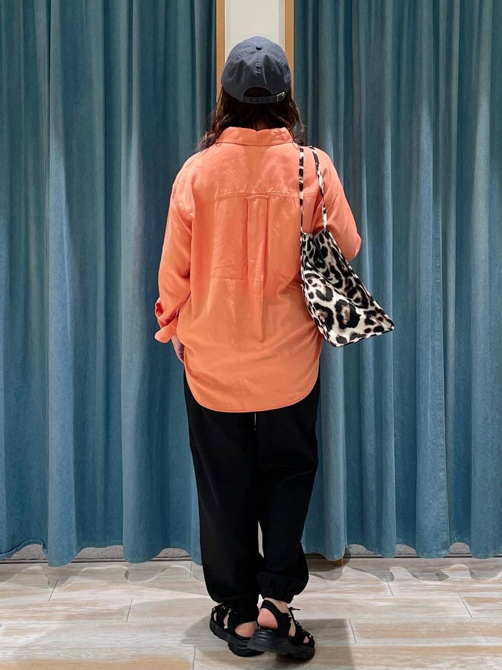 オレンジ系のシャツ/ブラウス、ブラック系のその他パンツ、ベージュ系のトートバッグを着用したレディースの春コーディネートの3枚目の写真