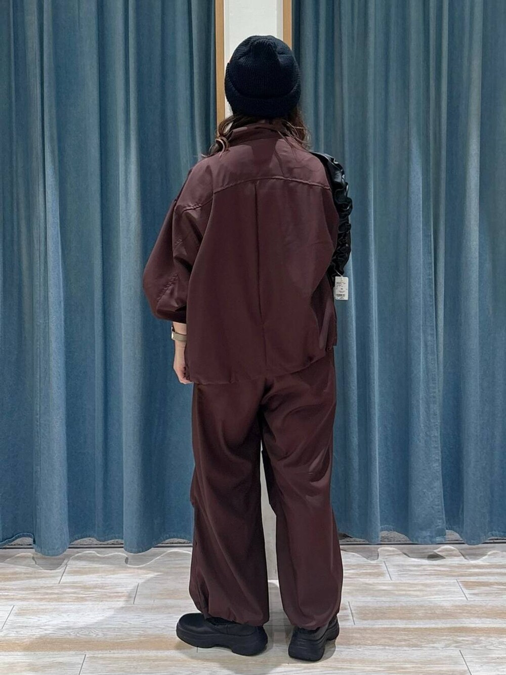 ブラック系のブーツ、ブラック系のショルダーバッグ、グレー系のネックレスを着用したレディースの秋コーディネートの3枚目の写真