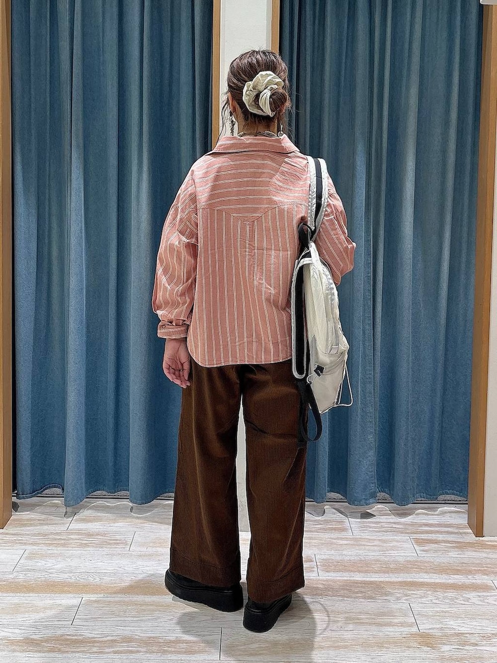 ブラウン系のその他パンツ、ホワイト系のバックパック/リュック、ブラック系のブーツを着用したレディースの秋コーディネートの3枚目の写真