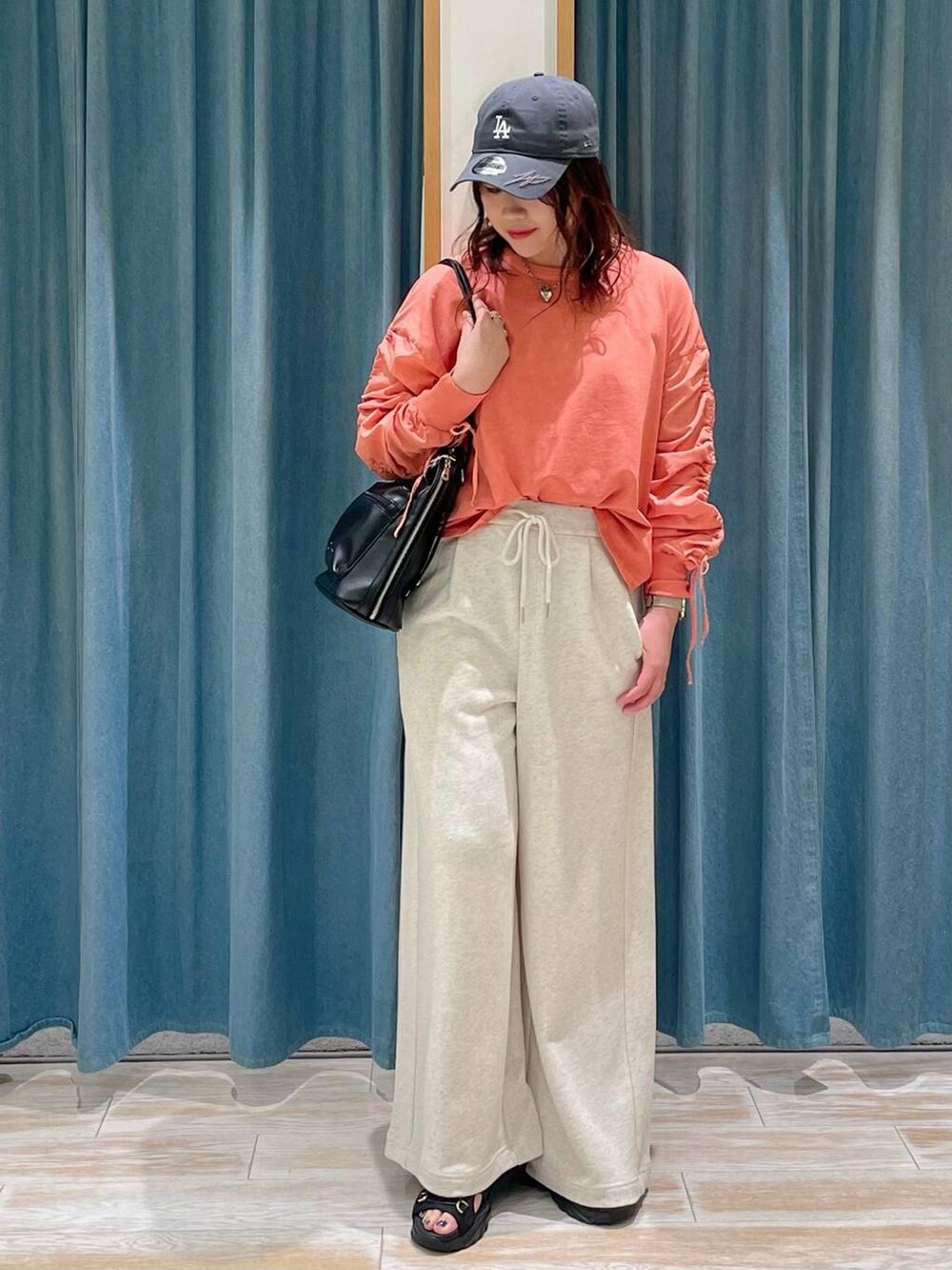 ベージュ系のスウェットパンツ、ブラック系のサンダル、ブラック系のバックパック/リュックを着用したレディースの春コーディネートの4枚目の写真