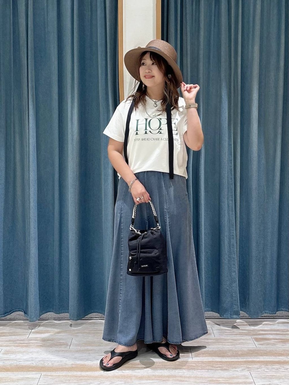 ホワイト系のTシャツ/カットソー、ブラック系のショルダーバッグ、ブルー系のスカートを着用したレディースの夏コーディネートの4枚目の写真