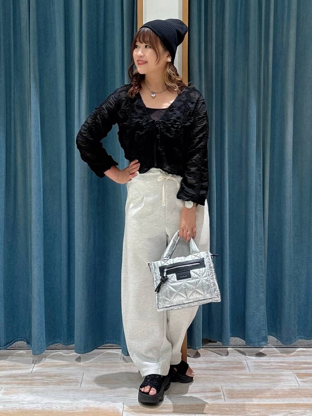 シルバー系のショルダーバッグ、ベージュ系のその他パンツ、ブラック系のカーディガン/ボレロを着用したレディースの夏コーディネートの4枚目の写真