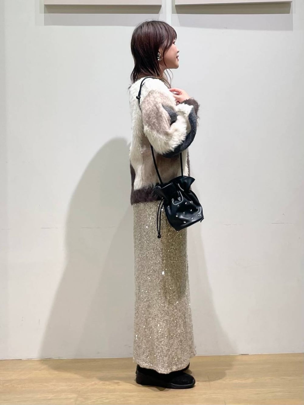 ブラック系のショルダーバッグ、ブラック系のブーツ、ブラウン系のニット/セーターを着用したレディースの秋コーディネートの2枚目の写真