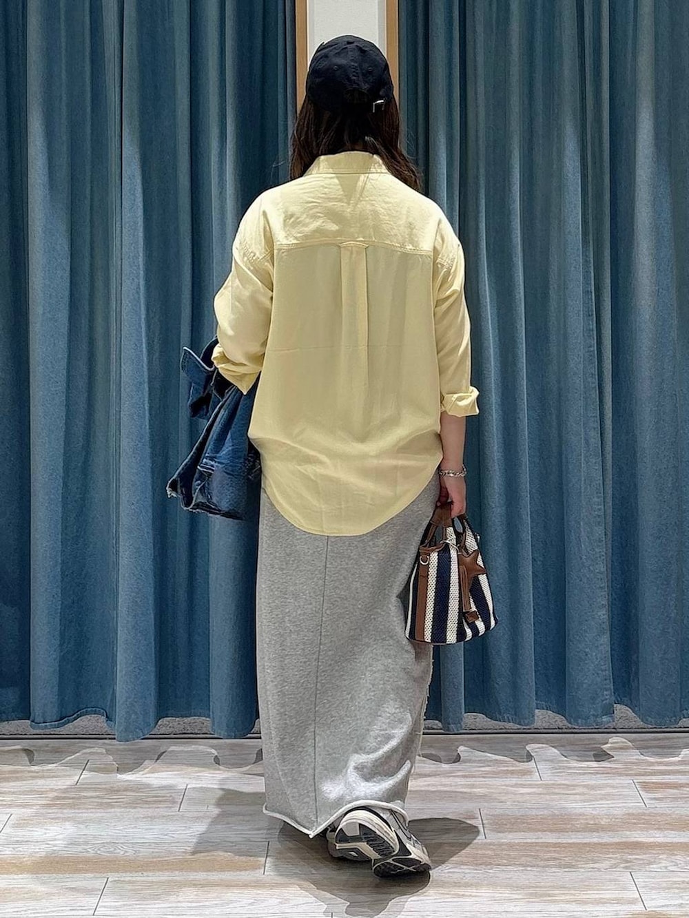 イエロー系のシャツ/ブラウス、ブルー系のデニムジャケット、グレー系のスカートを着用したレディースの春コーディネートの3枚目の写真