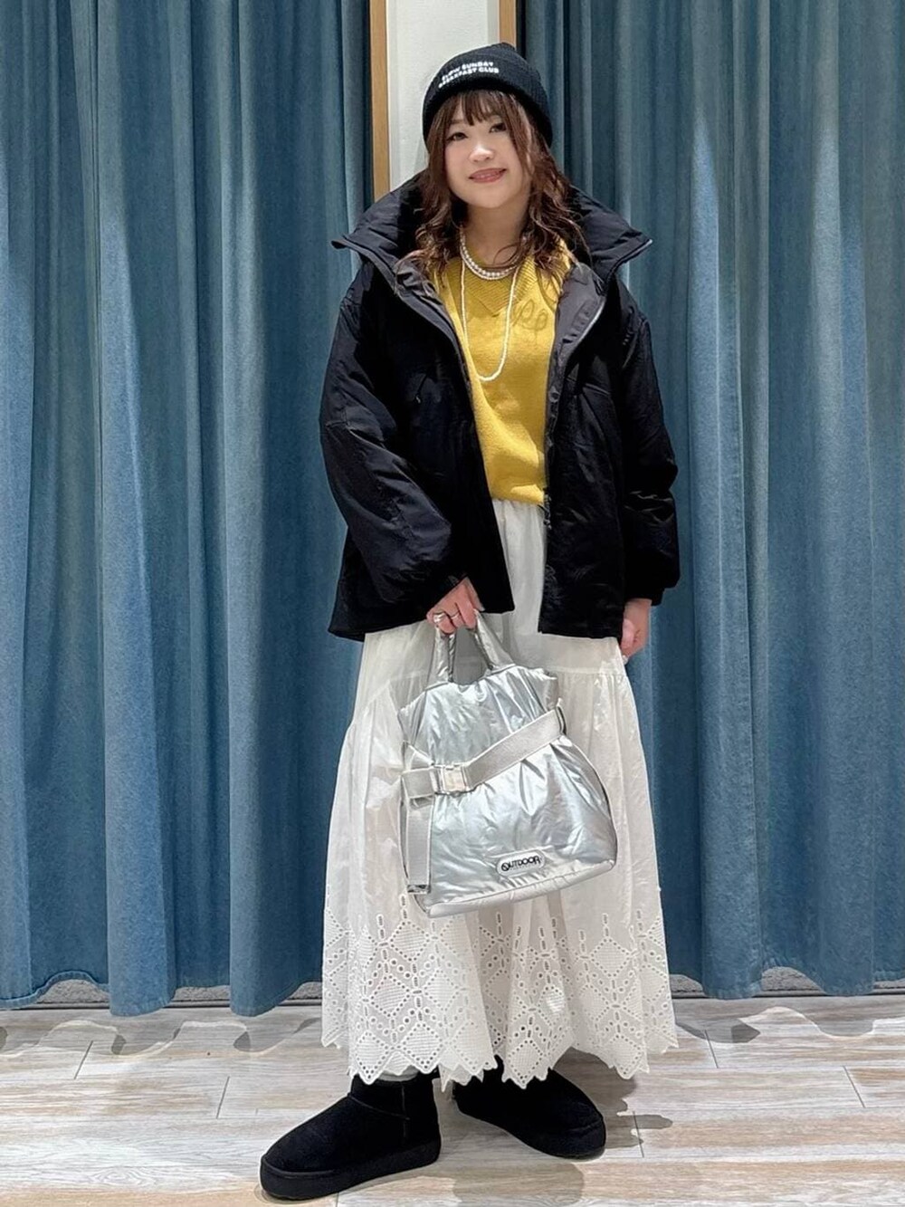 シルバー系のトートバッグ、ブラック系のブーツ、イエロー系のニット/セーターを着用したレディースの秋コーディネートの4枚目の写真