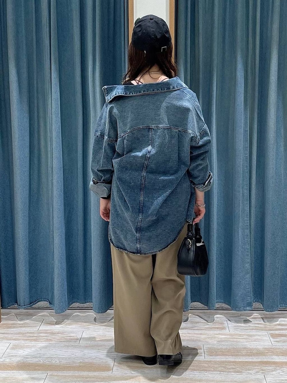 ブラック系のハンドバッグ、ブラック系のローファー、ブルー系のシャツ/ブラウスを着用したレディースの春コーディネートの3枚目の写真