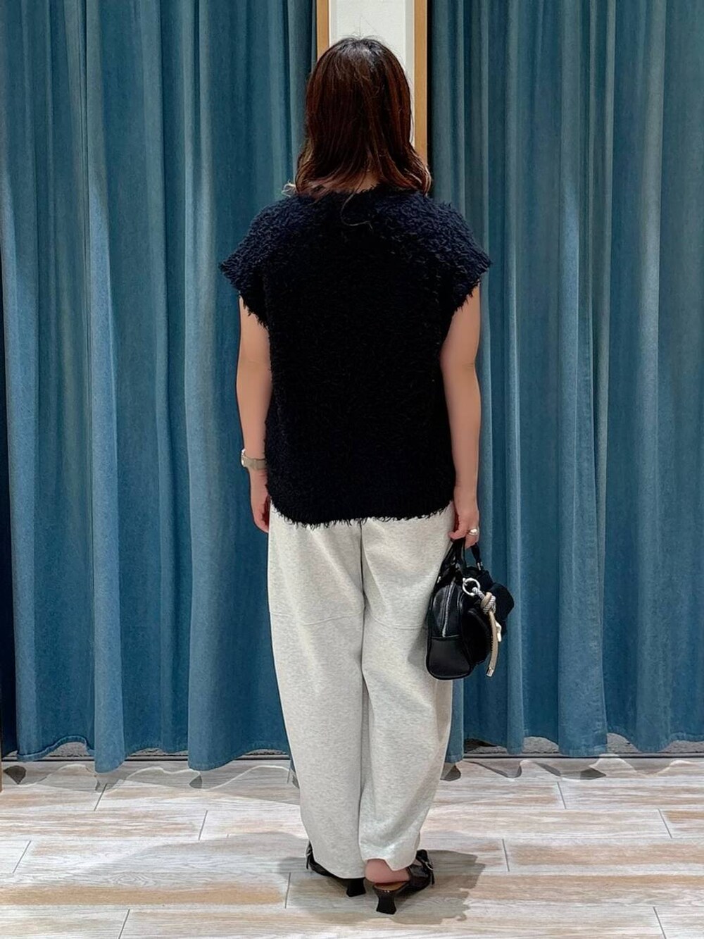 ブラック系のその他シューズ、ブラック系のボストンバッグ、ベージュ系のその他パンツを着用したレディースの夏コーディネートの3枚目の写真