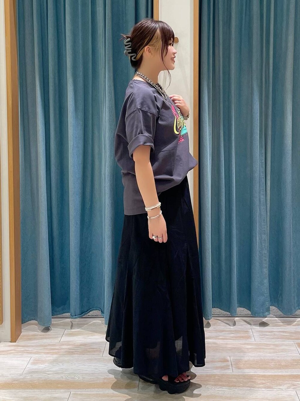 ブラック系のスカート、グレー系のTシャツ/カットソー、シルバー系のショルダーバッグを着用したレディースの夏コーディネートの2枚目の写真