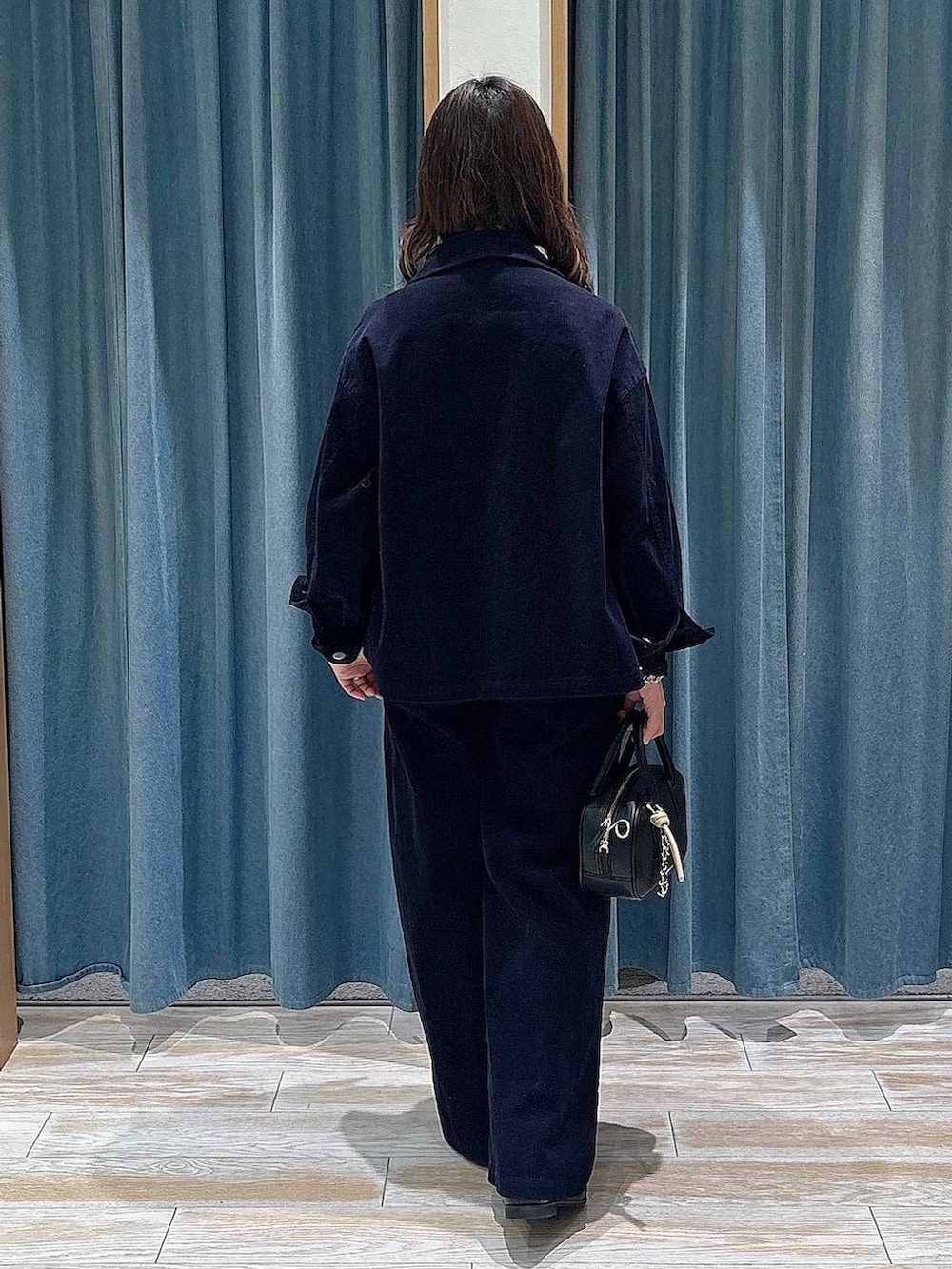 ブラック系のTシャツ/カットソー、ブラック系のローファー、ブラック系のハンドバッグを着用したレディースの冬コーディネートの3枚目の写真