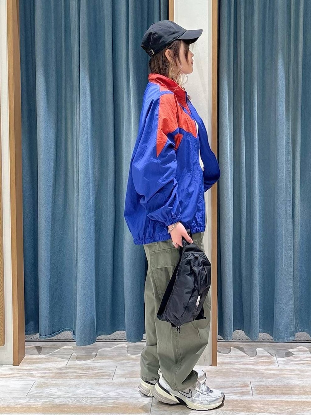 ブラック系のショルダーバッグ、グリーン系のカーゴパンツ、ホワイト系のTシャツ/カットソーを着用したレディースの春コーディネートの2枚目の写真