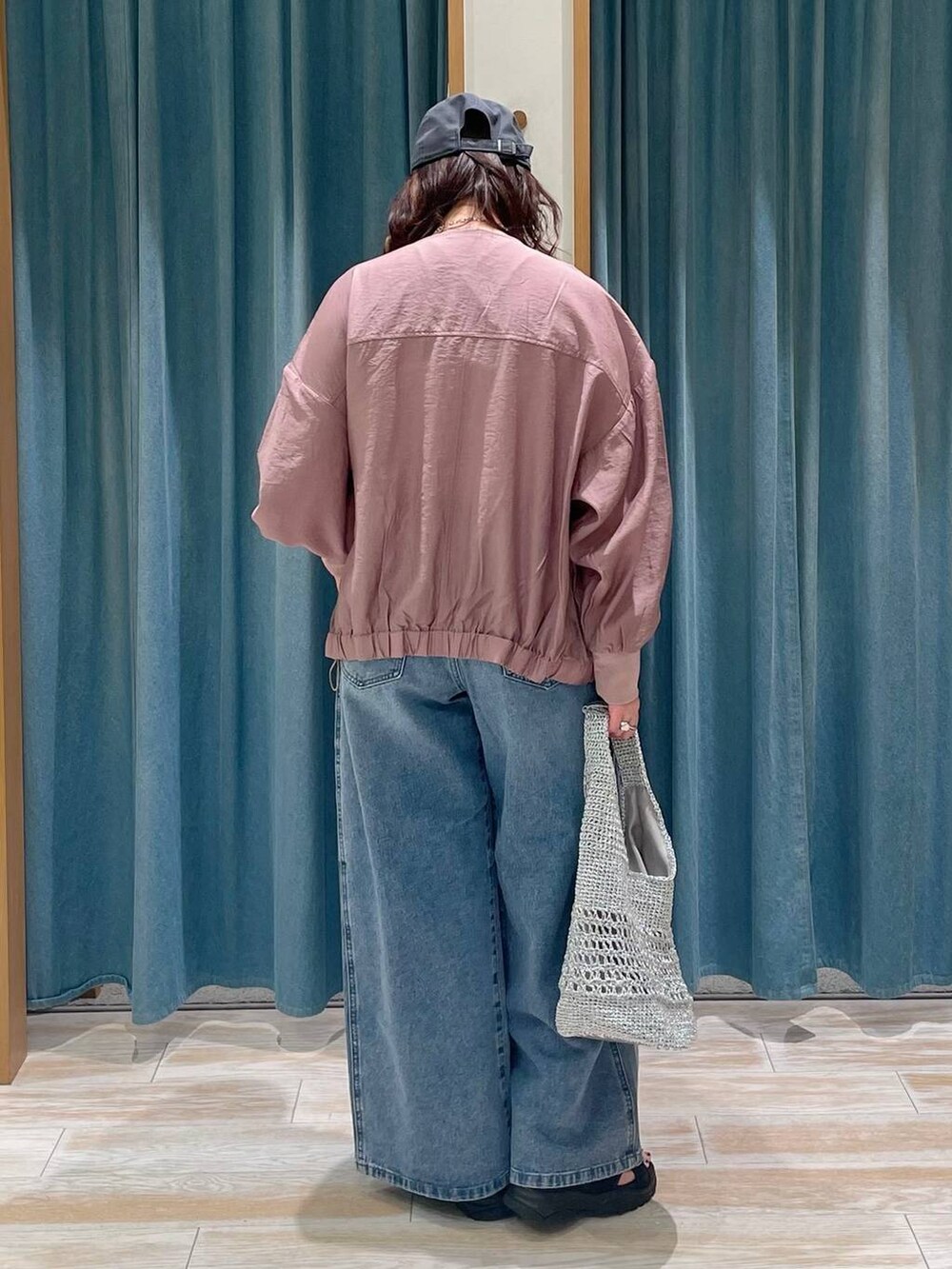 ホワイト系のキャミソール、ブルー系のデニムパンツ、グレー系のハンドバッグを着用したレディースの春コーディネートの3枚目の写真