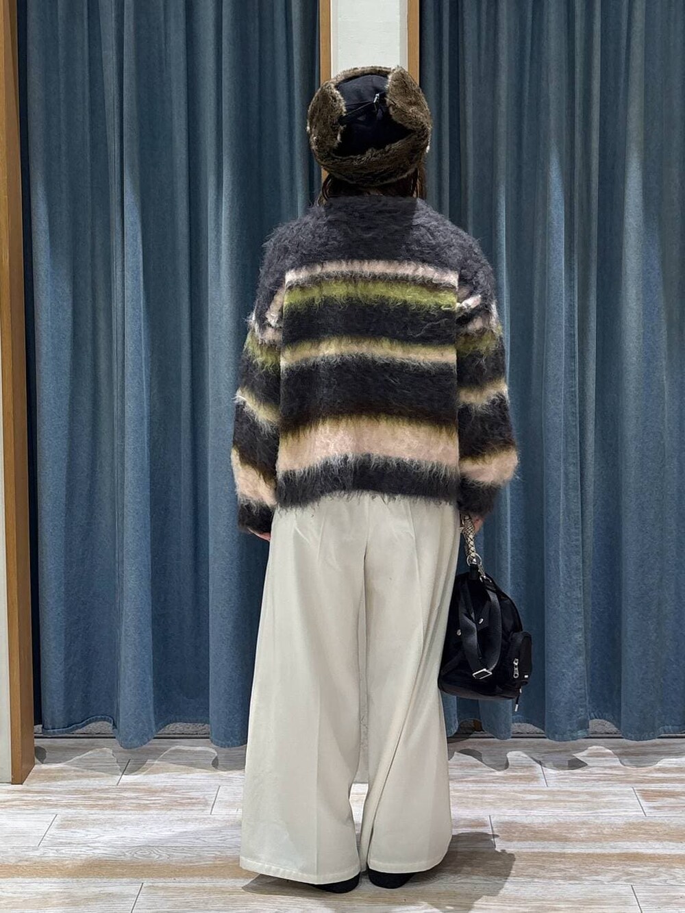 ベージュ系のその他パンツ、ブラック系のブーツ、ブラック系のハンドバッグを着用したレディースの冬コーディネートの3枚目の写真