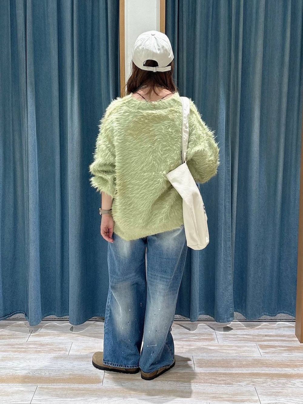 ベージュ系のその他シューズ、グリーン系のカーディガン/ボレロ、ホワイト系のトートバッグを着用したレディースの秋コーディネートの3枚目の写真