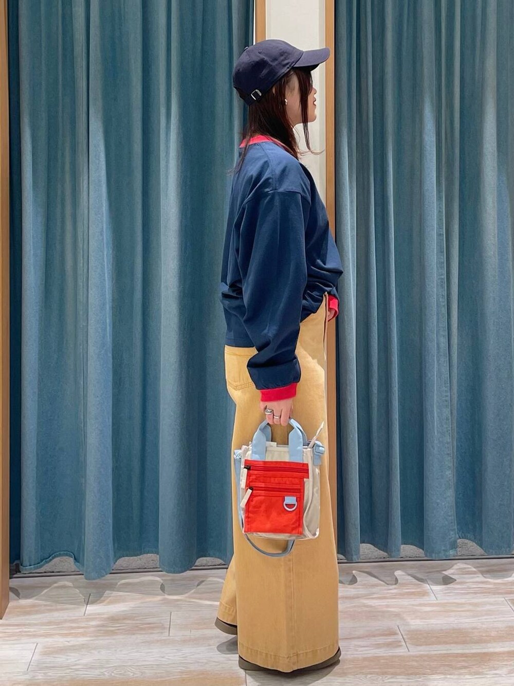 ブラック系のスニーカー、オレンジ系のデニムパンツ、ブルー系のTシャツ/カットソーを着用したレディースの冬コーディネートの2枚目の写真