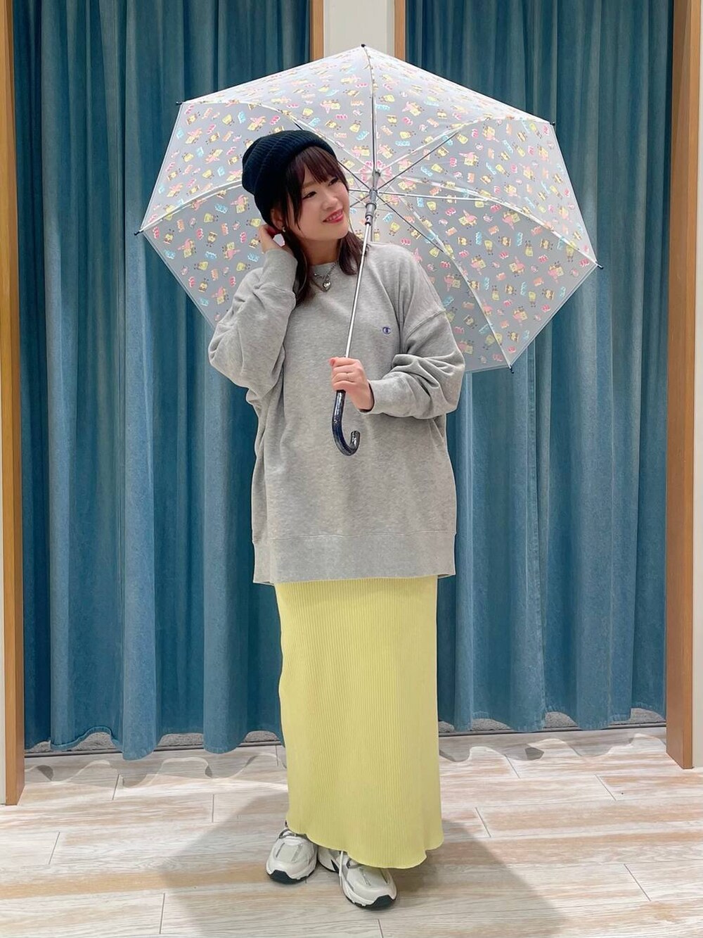 レッド系のトートバッグ、イエロー系のスカート、グレー系のスウェットを着用したレディースの冬コーディネートの2枚目の写真