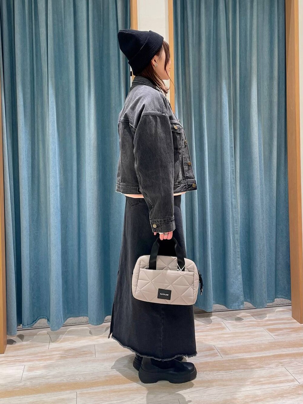 グレー系のデニムジャケット、ブラック系のブーツ、ピンク系のスウェットを着用したレディースの冬コーディネートの2枚目の写真