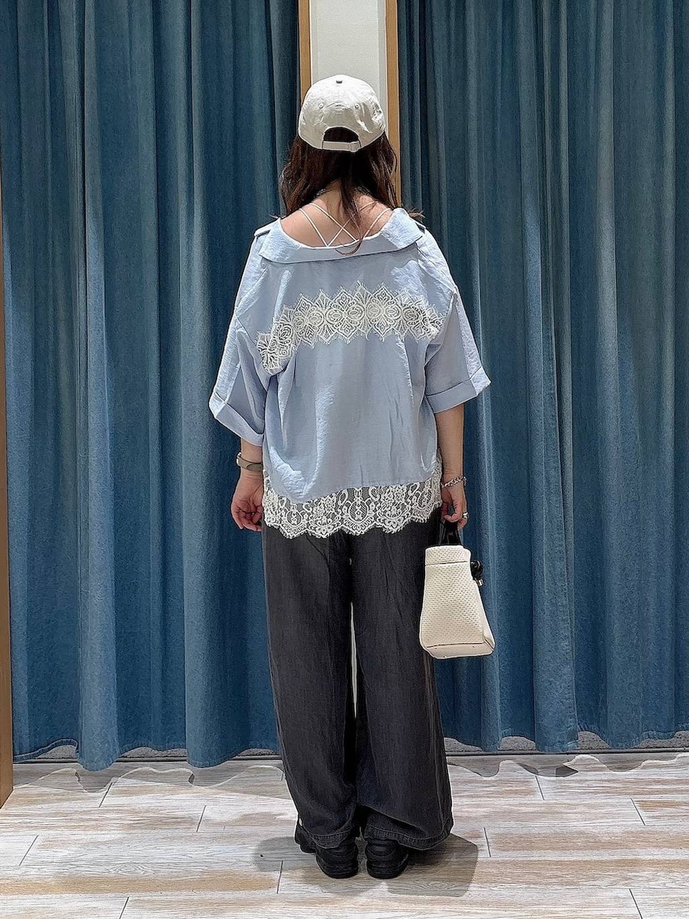 ブラック系のデニムパンツ、ベージュ系のショルダーバッグ、ホワイト系のキャミソールを着用したレディースの夏コーディネートの3枚目の写真