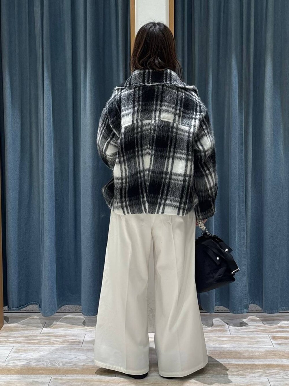 ベージュ系のその他パンツ、ブラック系のブーツ、ブラック系のハンドバッグを着用したレディースの冬コーディネートの3枚目の写真