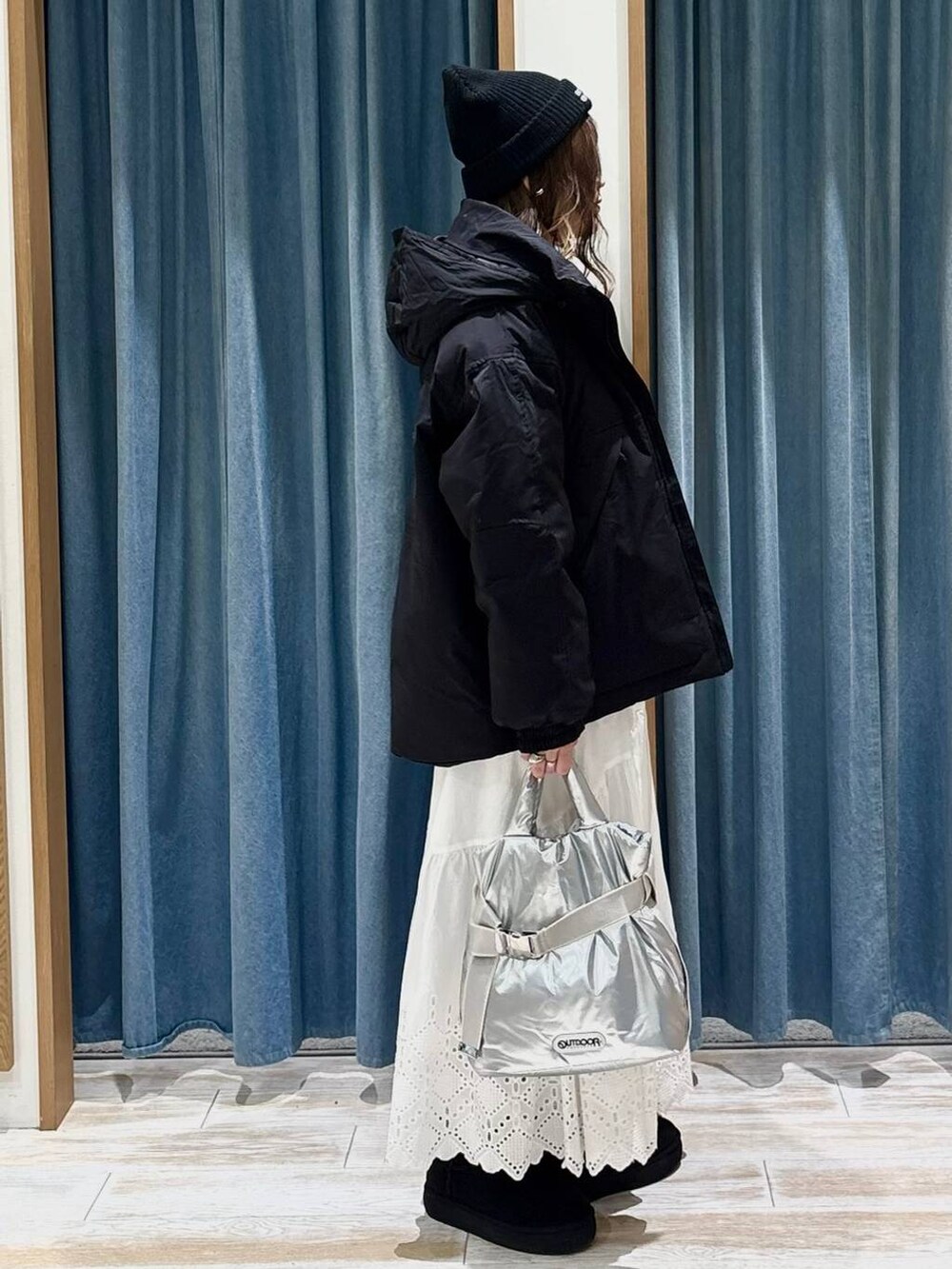 シルバー系のトートバッグ、ブラック系のブーツ、イエロー系のニット/セーターを着用したレディースの秋コーディネートの2枚目の写真