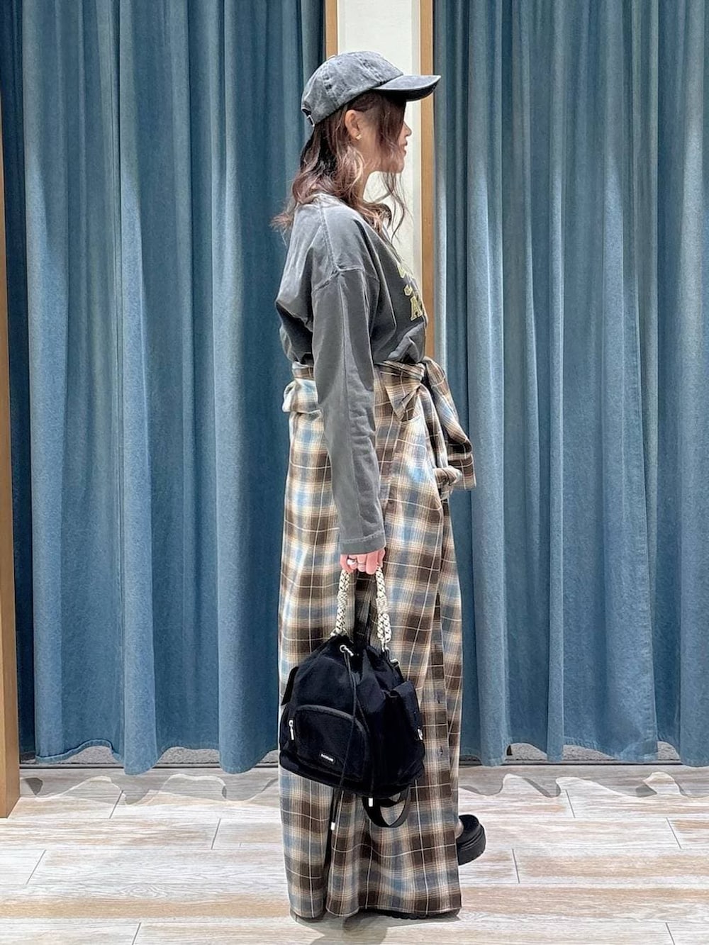 ブラック系のブーツ、ブラック系のハンドバッグ、グレー系のTシャツ/カットソーを着用したレディースの冬コーディネートの2枚目の写真