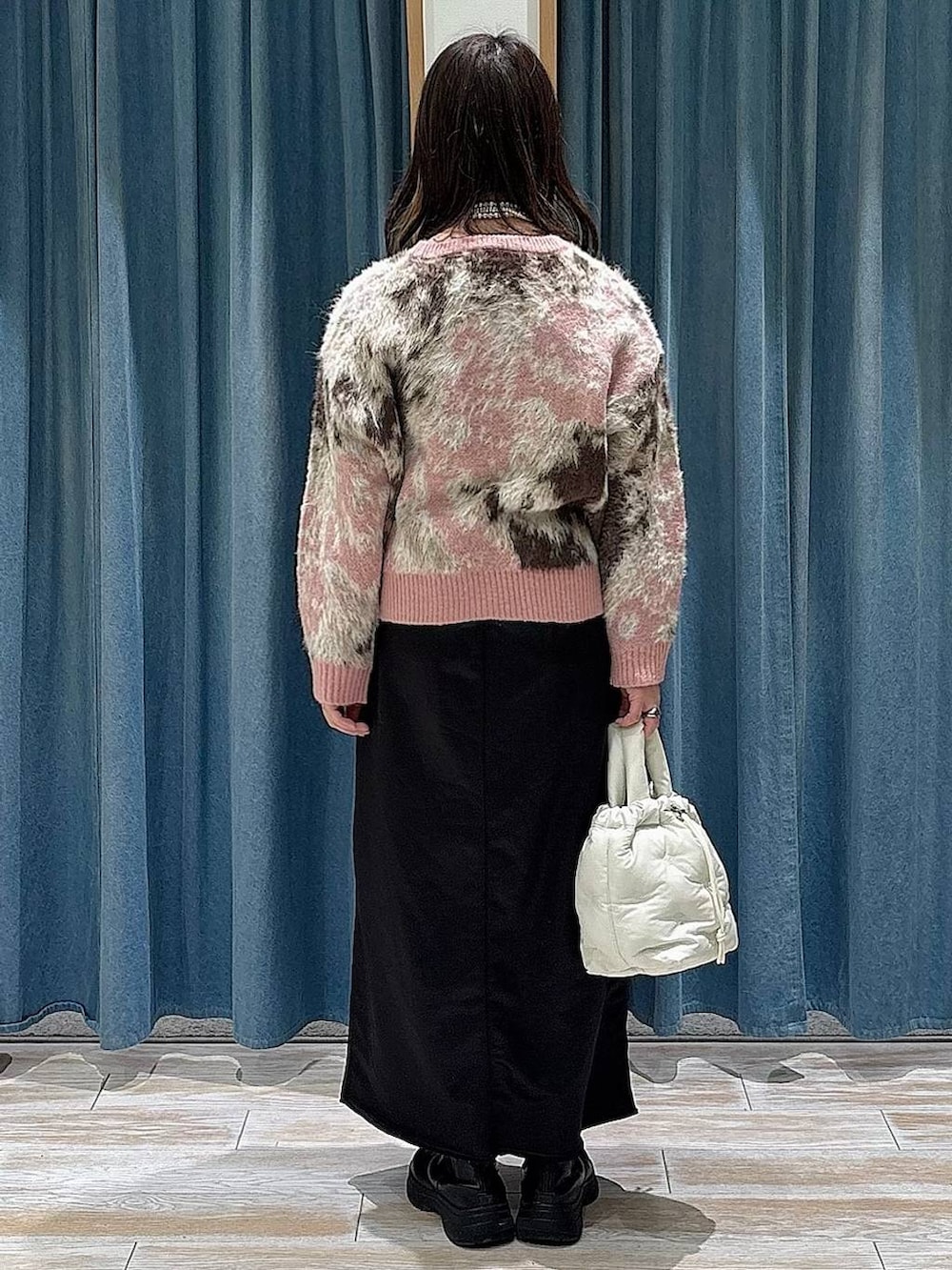 ブラック系のブーツ、ブラック系のスカート、ピンク系のニット/セーターを着用したレディースの冬コーディネートの3枚目の写真