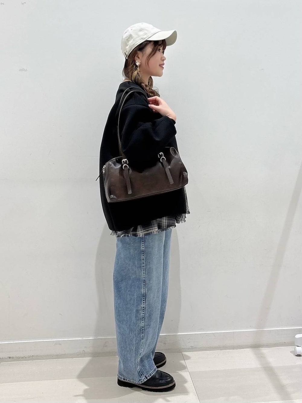 ブラック系のブルゾン、ブラック系のTシャツ/カットソー、ブルー系のデニムパンツを着用したレディースの春コーディネートの2枚目の写真