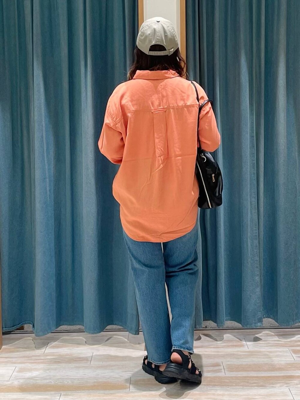 オレンジ系のシャツ/ブラウス、ブルー系のデニムパンツ、ブラック系のサンダルを着用したレディースの春コーディネートの3枚目の写真