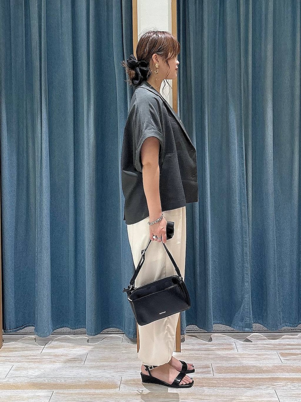 ベージュ系のその他パンツ、ブラック系のサンダル、ブラック系のショルダーバッグを着用したレディースの夏コーディネートの2枚目の写真