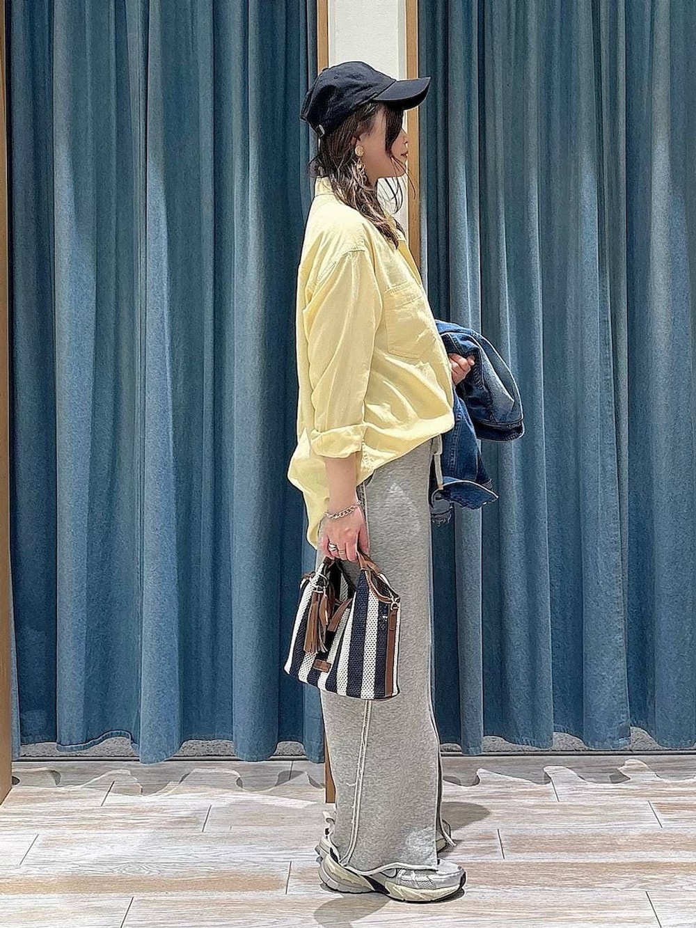 イエロー系のシャツ/ブラウス、ブルー系のデニムジャケット、グレー系のスカートを着用したレディースの春コーディネートの2枚目の写真