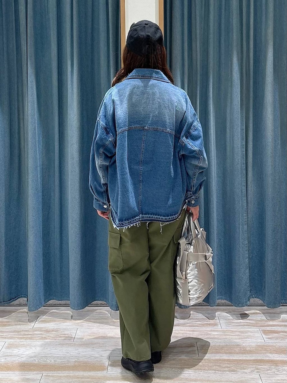 シルバー系のトートバッグ、ホワイト系のTシャツ/カットソー、グリーン系のカーゴパンツを着用したレディースの冬コーディネートの3枚目の写真