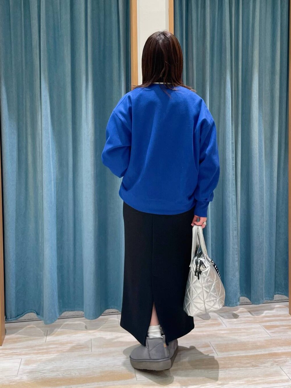 ブラック系のニット/セーター、シルバー系のトートバッグ、ブルー系のブルゾンを着用したレディースの冬コーディネートの3枚目の写真