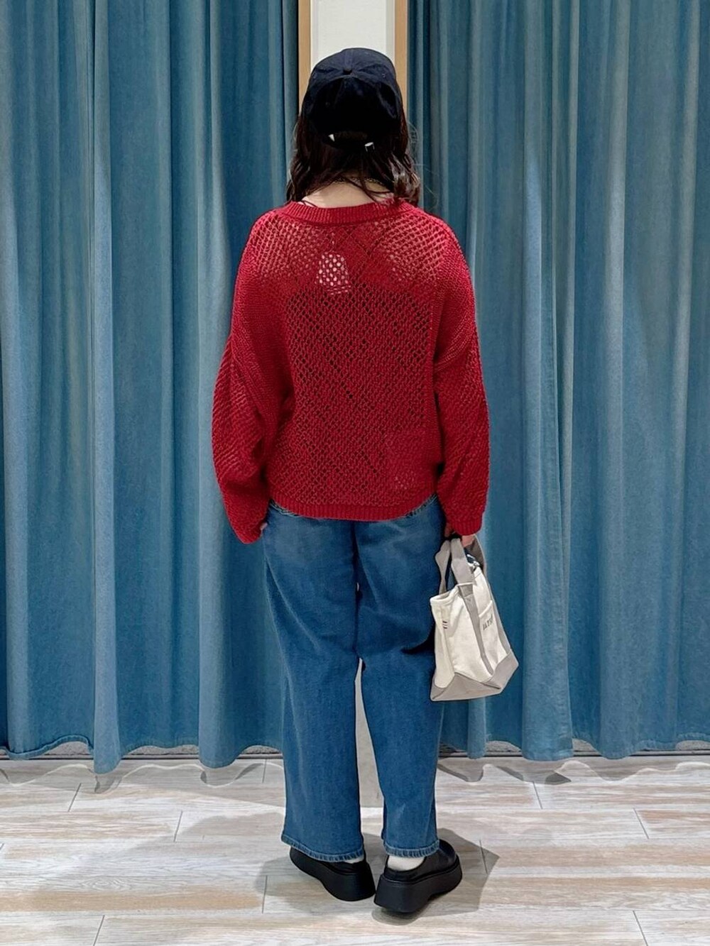 ブラック系のキャミソール、ブラック系のサンダル、ブルー系のデニムパンツを着用したレディースの秋コーディネートの3枚目の写真