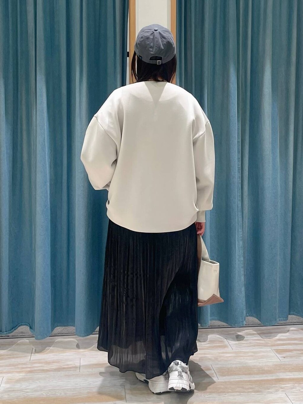 ホワイト系のTシャツ/カットソー、ブラウン系のトートバッグ、ブラック系のスカートを着用したレディースの冬コーディネートの3枚目の写真