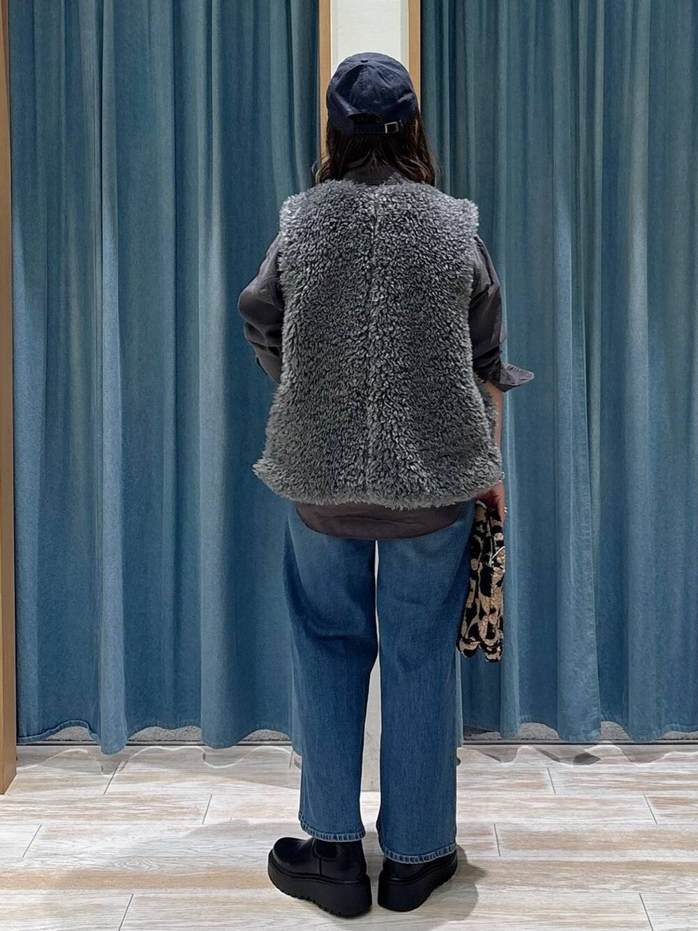 グレー系のシャツ/ブラウス、ブラウン系のトートバッグ、ブラック系のブーツを着用したレディースの秋コーディネートの3枚目の写真