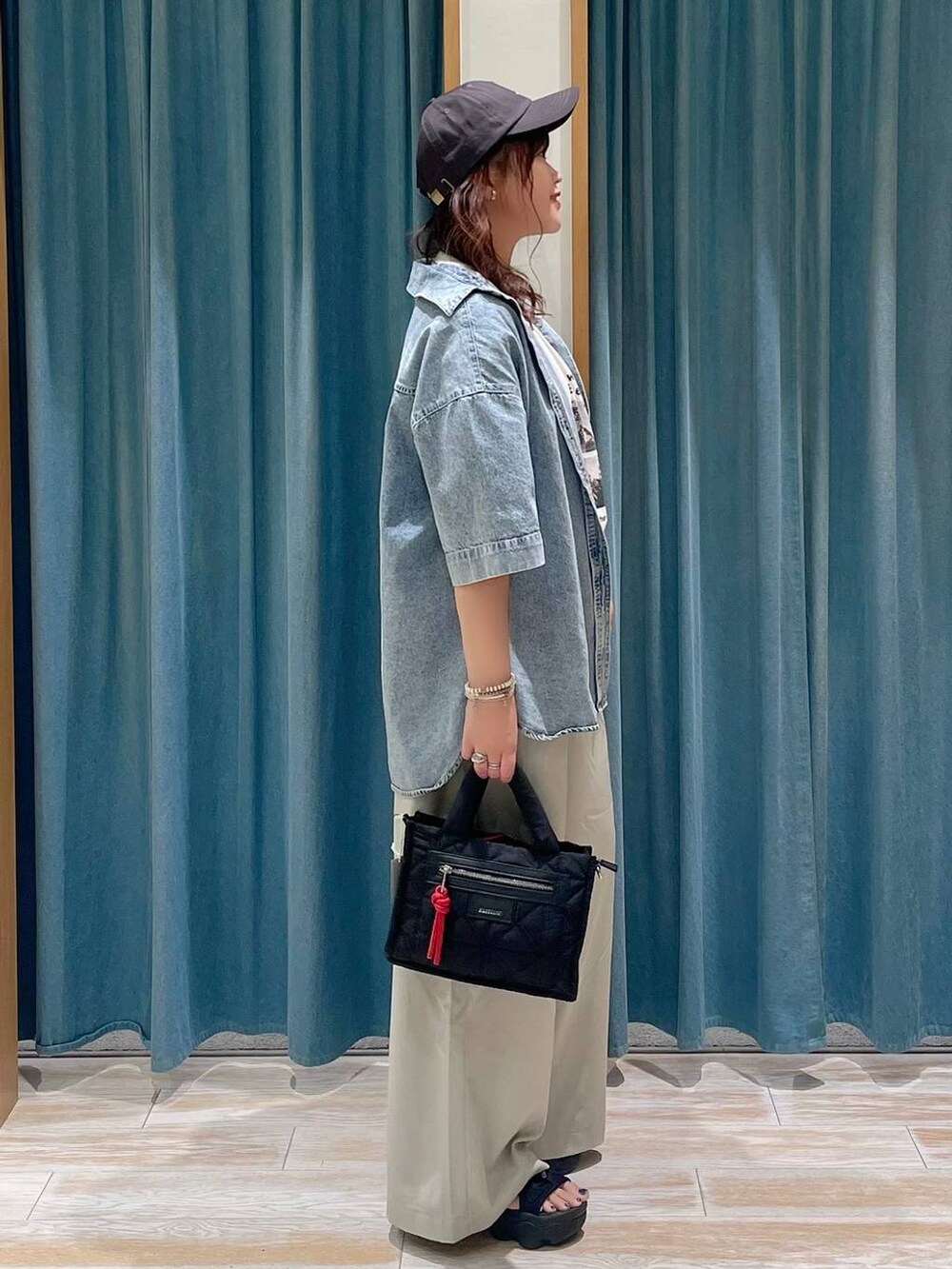 ベージュ系のその他パンツ、ブラック系のショルダーバッグ、ホワイト系のTシャツ/カットソーを着用したレディースの夏コーディネートの2枚目の写真