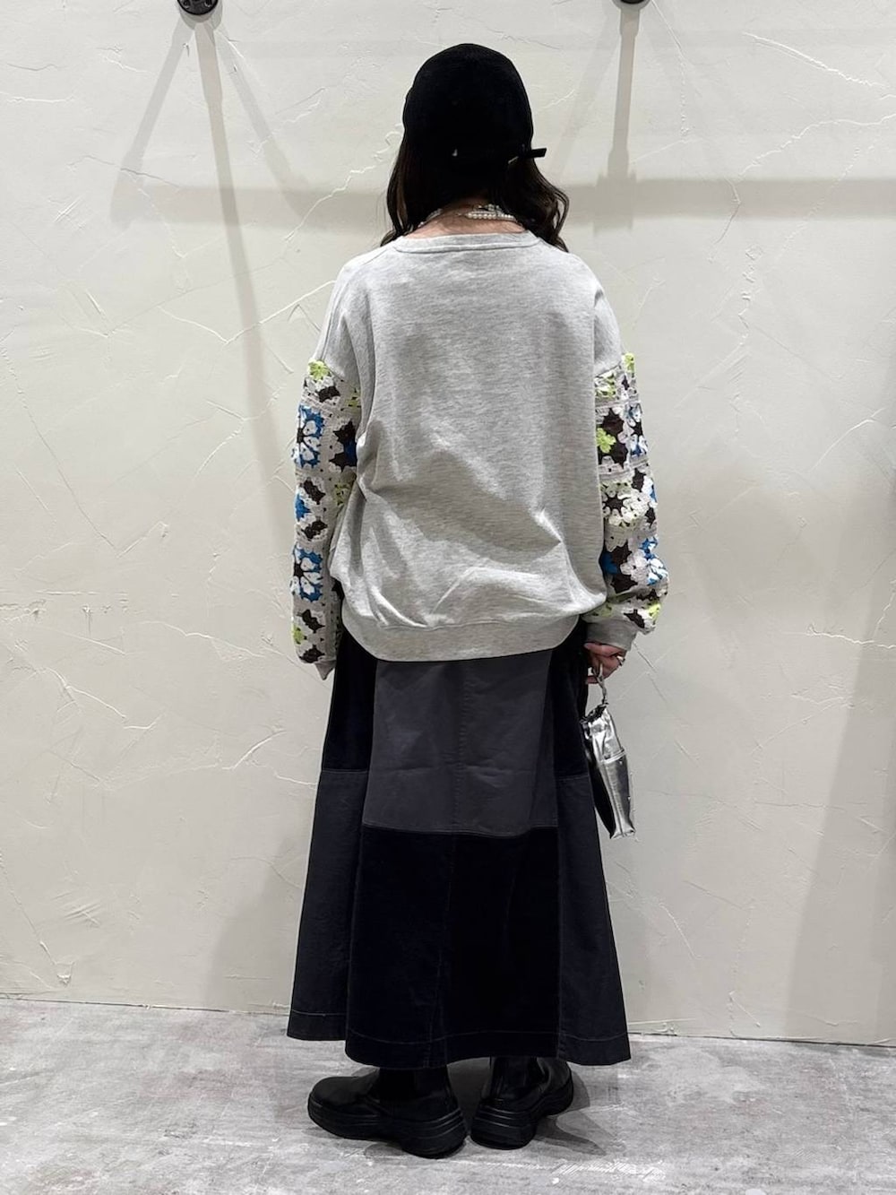 シルバー系のショルダーバッグ、グレー系のスウェット、グレー系のスカートを着用したレディースの冬コーディネートの3枚目の写真