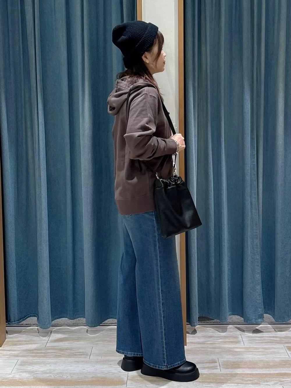 ブラック系のキャミソール、ブラウン系のパーカー、ブラック系のサンダルを着用したレディースの秋コーディネートの2枚目の写真