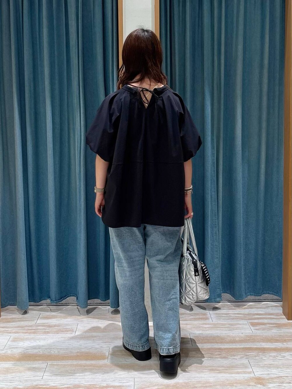 ブルー系のデニムパンツ、ブラック系のシャツ/ブラウス、ブラック系のサンダルを着用したレディースの夏コーディネートの3枚目の写真