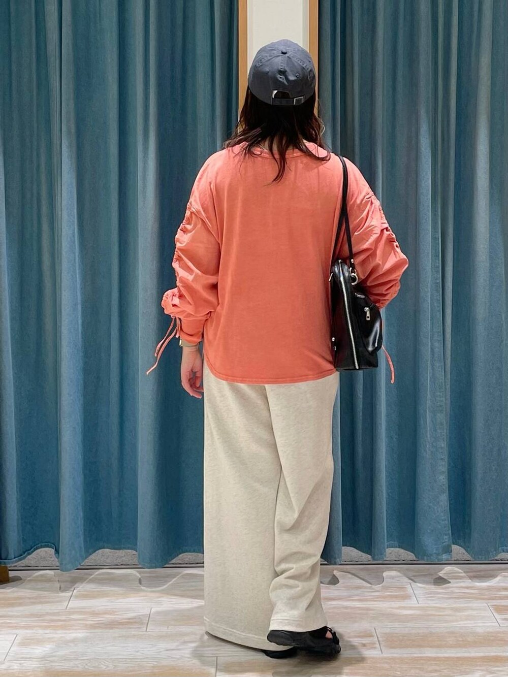 ベージュ系のスウェットパンツ、ブラック系のサンダル、ブラック系のバックパック/リュックを着用したレディースの春コーディネートの3枚目の写真