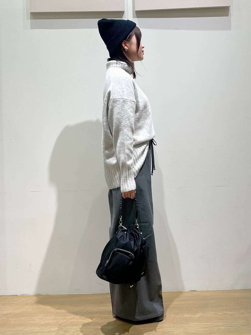 ブラック系のショルダーバッグ、グレー系のニット/セーター、グレー系のその他パンツを着用したレディースの秋コーディネートの2枚目の写真