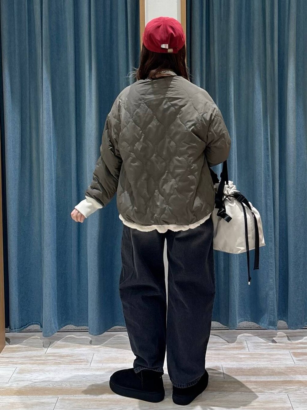 ホワイト系のトートバッグ、ブラック系のブーツ、ホワイト系のブルゾンを着用したレディースの秋コーディネートの3枚目の写真