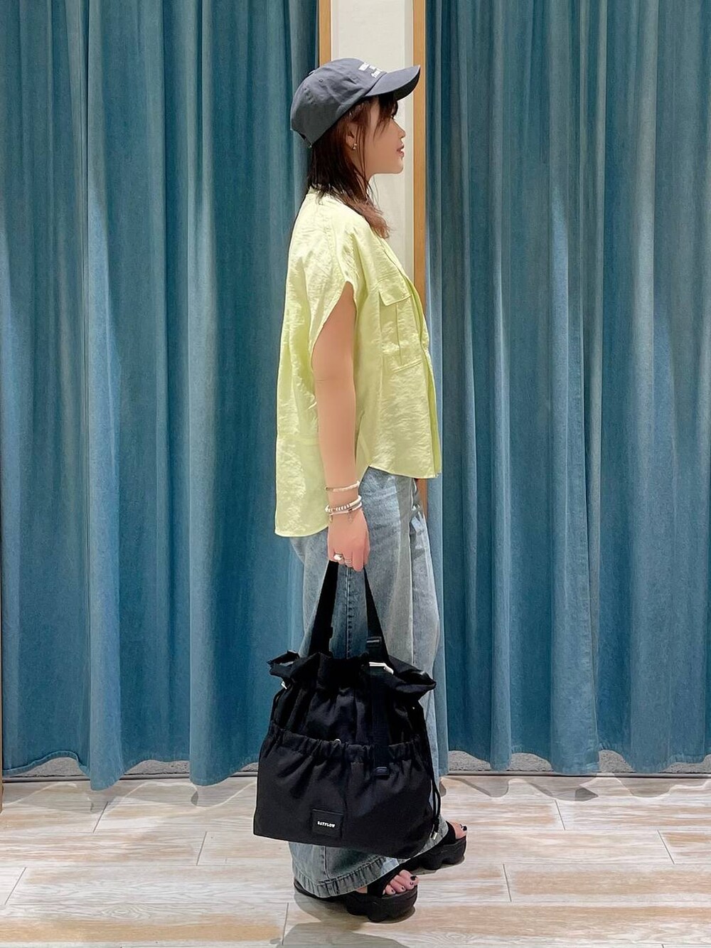 ホワイト系のキャミソール、ブラック系のトートバッグ、イエロー系のシャツ/ブラウスを着用したレディースの春コーディネートの2枚目の写真