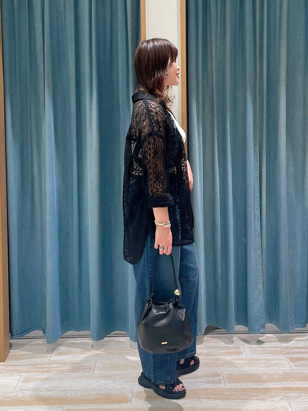 ホワイト系のキャミソール、ブラック系のシャツ/ブラウス、ブラック系のサンダルを着用したレディースの春コーディネートの2枚目の写真