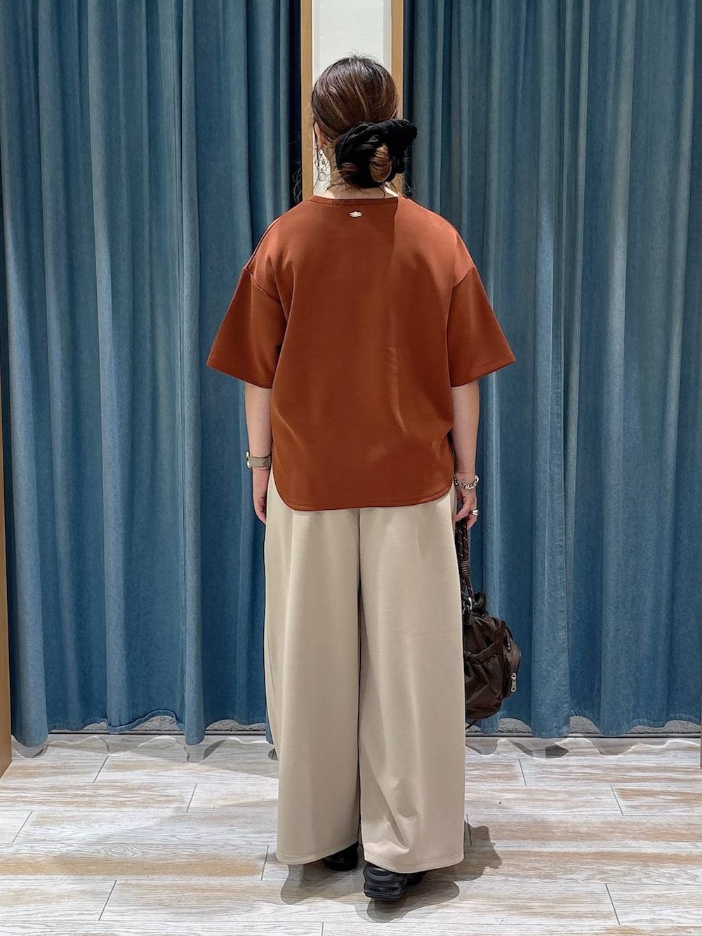 ブラウン系のショルダーバッグ、ベージュ系のその他パンツ、ブラウン系のTシャツ/カットソーを着用したレディースの夏コーディネートの3枚目の写真