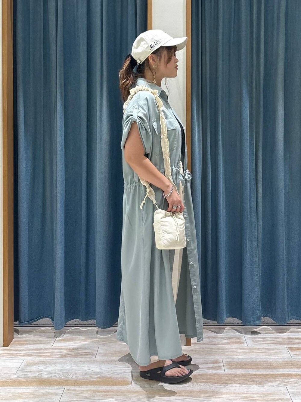 ベージュ系のその他パンツ、ブラック系のサンダル、ホワイト系のショルダーバッグを着用したレディースの夏コーディネートの2枚目の写真