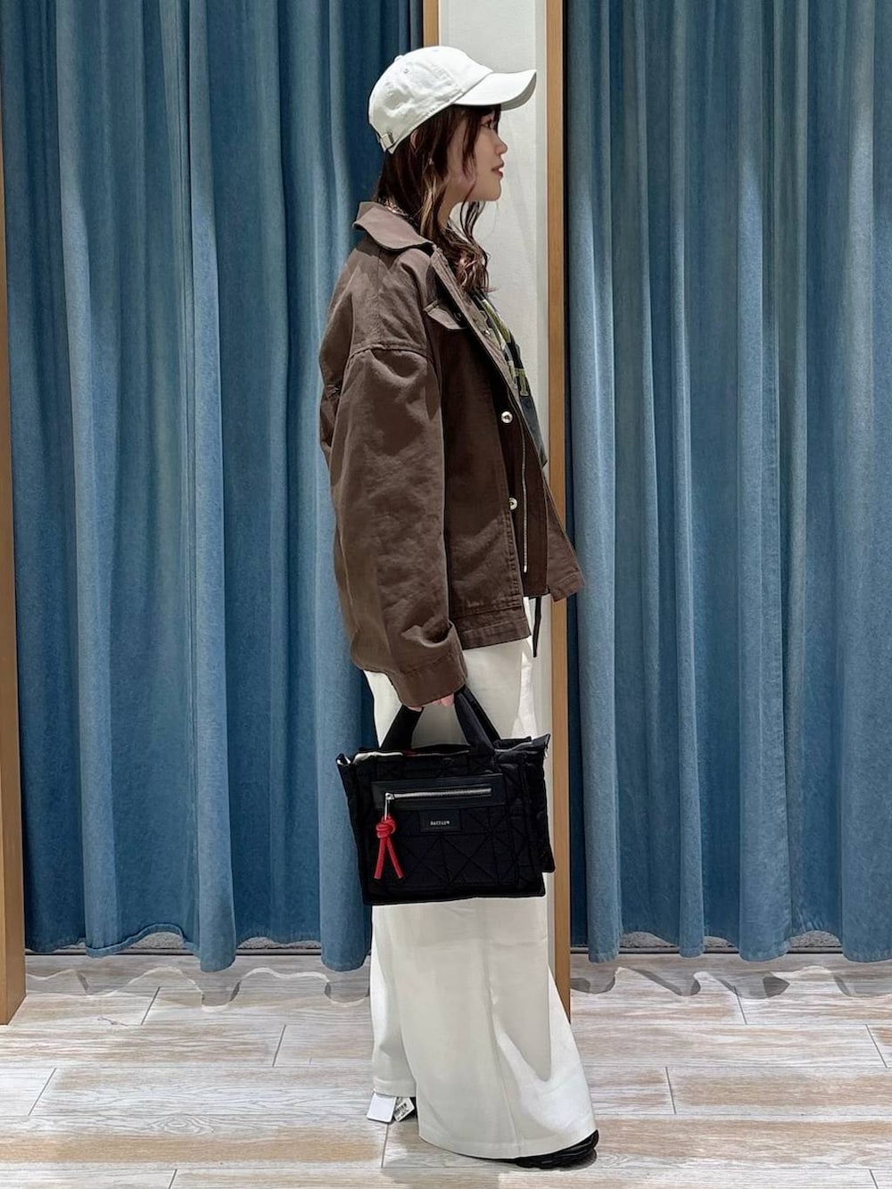 ブラック系のショルダーバッグ、グレー系のTシャツ/カットソー、ベージュ系のその他パンツを着用したレディースの冬コーディネートの2枚目の写真