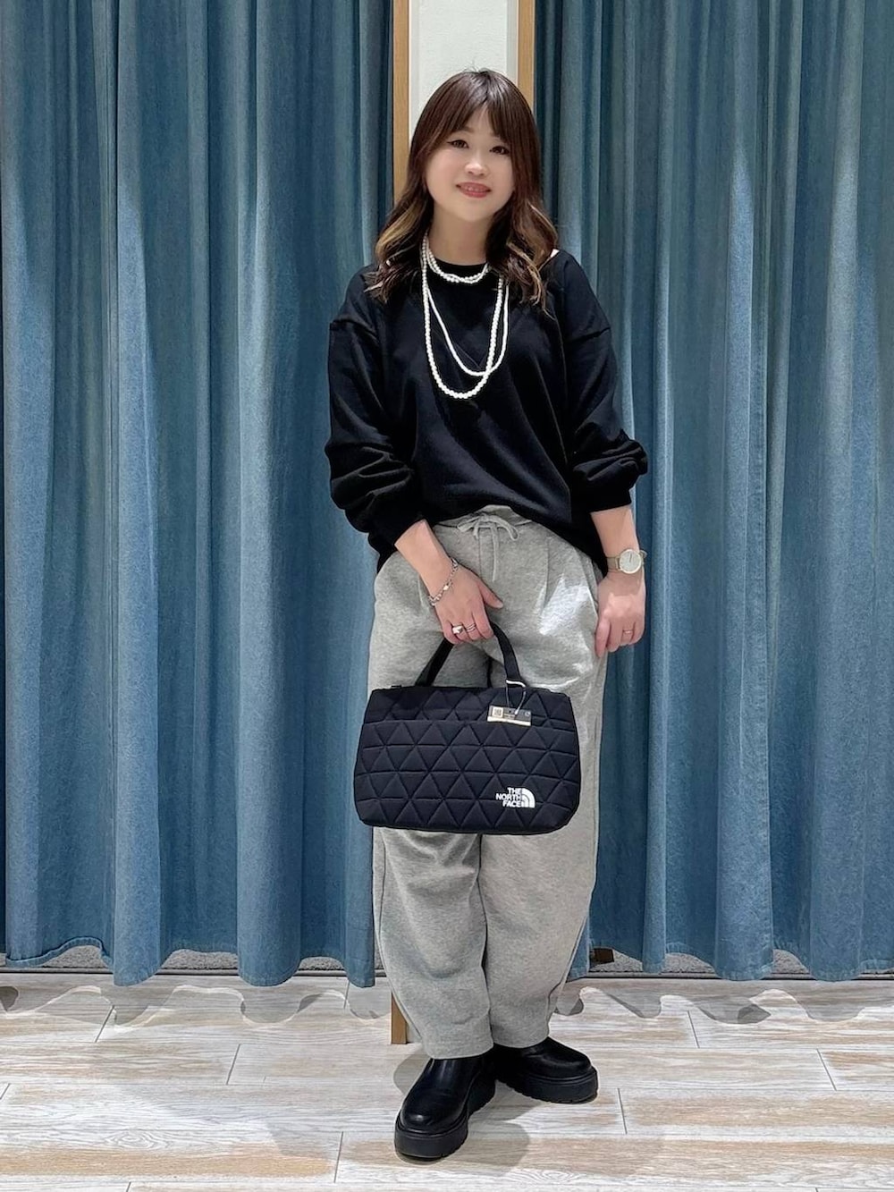 ブラック系のブーツ、ブラック系のトートバッグ、グレー系のその他パンツを着用したレディースの冬コーディネートの4枚目の写真